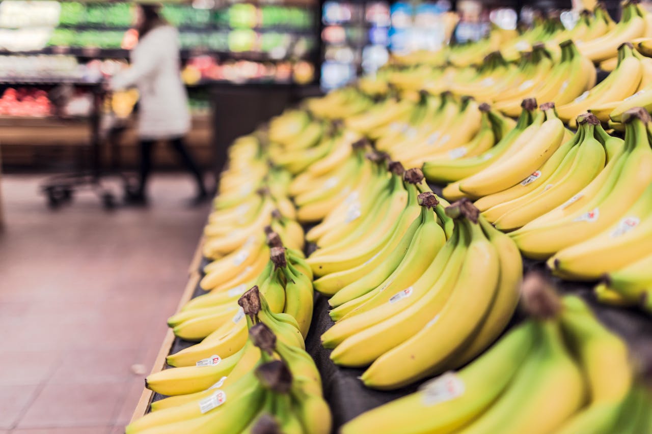 Servicios Rows of ripe bananas displayed attractively in a supermarket aisle.