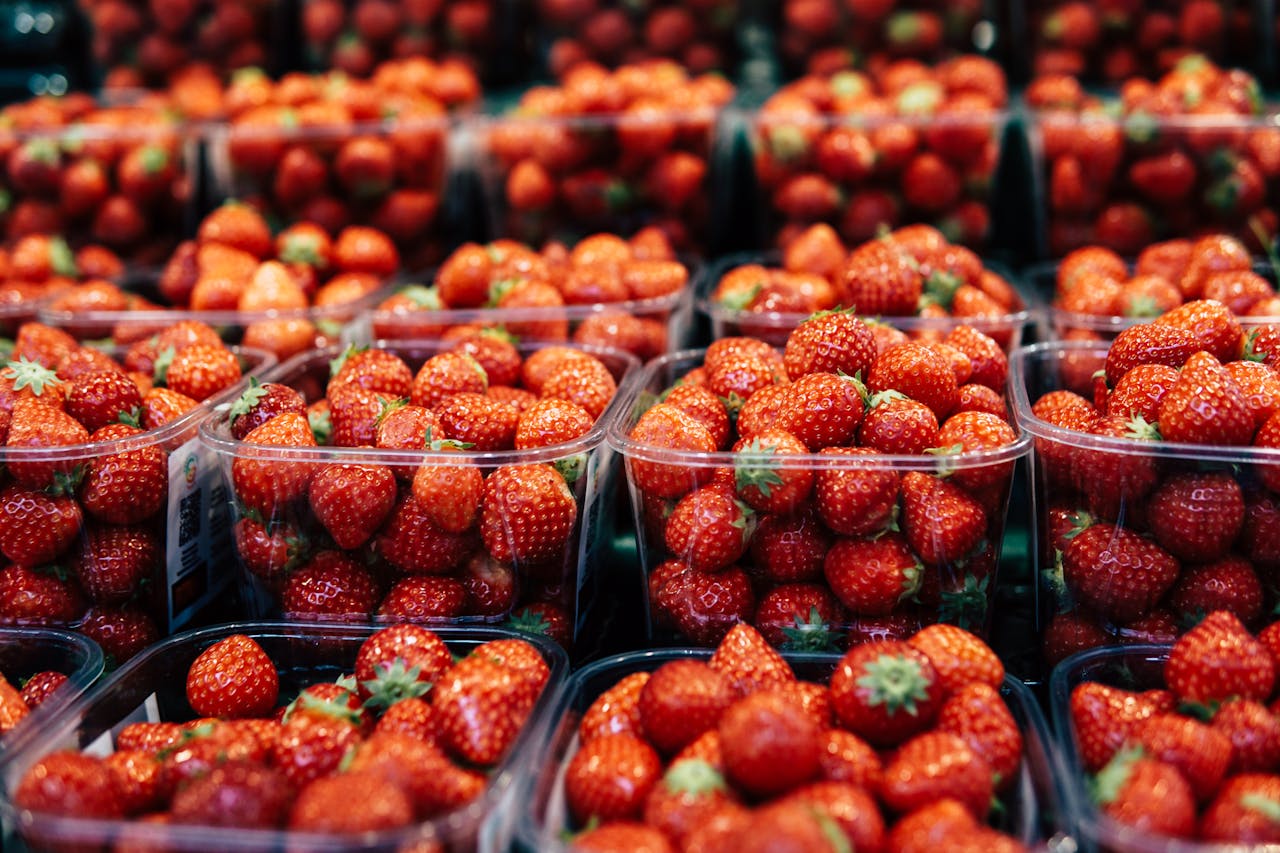 Bright and juicy strawberries packed in containers at a market. Perfect for healthy snacks.